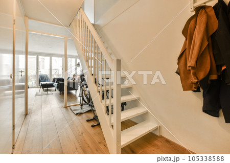 the inside of a house with clothes hanging on the wall and stairs leading up to the second floor in an apartment 105338588