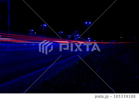 Lights of cars at night. Street line lights. Night highway city. Long exposure photograph night road. Colored bands of red light trails on the road. Background wallpaper defocused  105339188