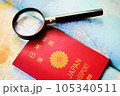 世界地図の上に置かれたパスポートと虫メガネ 105340511