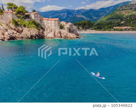 Young women Having Fun Stand Up Paddling in blue water sea near st stefan island in Montenegro. SUP 105340622