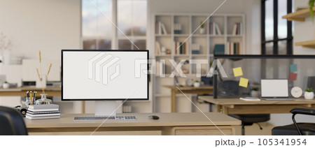 A computer mockup is on an office desk in a modern office co-working room. A computer mockup is on an office desk in a modern office co-working room. 105341954