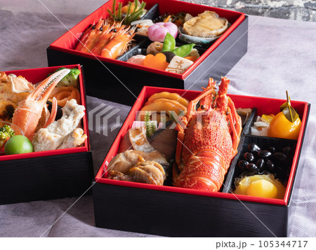 日本のお節料理。お正月の伝統料理。伊達巻や栗きんとん、伊勢海老やあわびなどが入った三段重箱。 日本のお節料理。お正月の伝統料理。伊達巻や栗きんとん、伊勢海老やあわびなどが入った三段重箱。 105344717