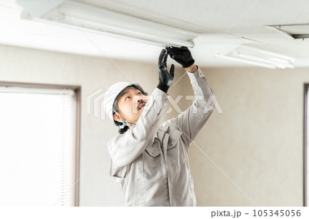 蛍光灯器具を点検する男性作業員 105345056