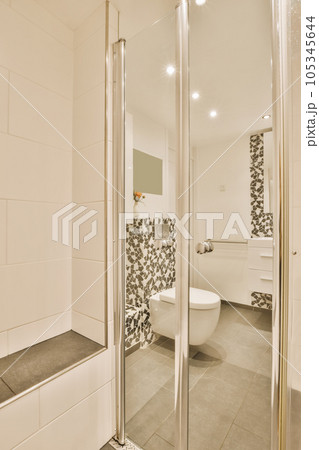 a modern bathroom with black and white tiles on the walls, floor, and shower stall in front of the mirror a modern bathroom with black and white tiles on the walls, floor, and shower stall in front of the mirror 105345644