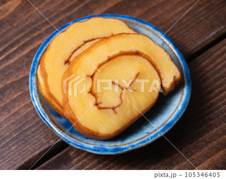 甘い味付けの伊達巻のクローズアップ。卵と魚のすり身を混ぜて焼いて巻いた卵焼き。 105346405