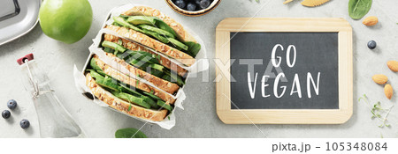 Go vegan chalk board and healthy sandwich flat lay 105348084