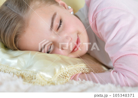Girl sleeps on a white pillow. 105348371