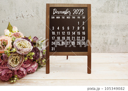 December 2023 monthly calendar with flower bouquet decoration on wooden background 105349082