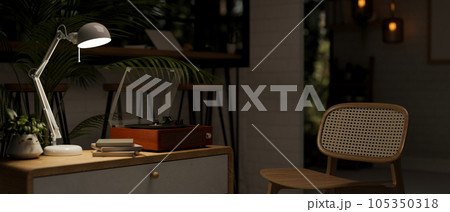 A vintage record player on a minimal drawer in a cozy and minimal living room at night. A vintage record player on a minimal drawer in a cozy and minimal living room at night. 105350318