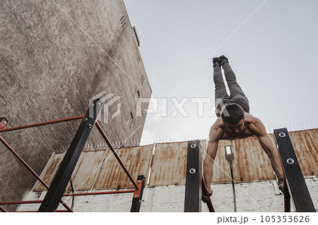 Shirtless athlete practicing calisthenics. Shirtless athlete practicing calisthenics. 105353626