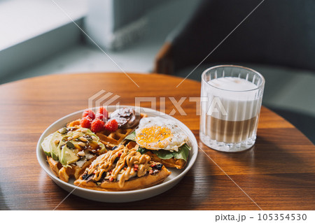 Homemade waffles with different toppings on a white plate with coffee Homemade waffles with different toppings on a white plate with coffee 105354530