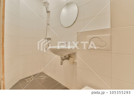 a bathroom with a sink, mirror and toilet paper dispensed on the wall next to the shower a bathroom with a sink, mirror and toilet paper dispensed on the wall next to the shower 105355293