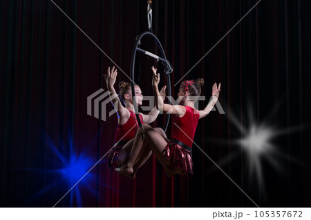 Circus actress acrobat performance. Two girls perform acrobatic elements in the air ring. Circus actress acrobat performance. Two girls perform acrobatic elements in the air ring. 105357672