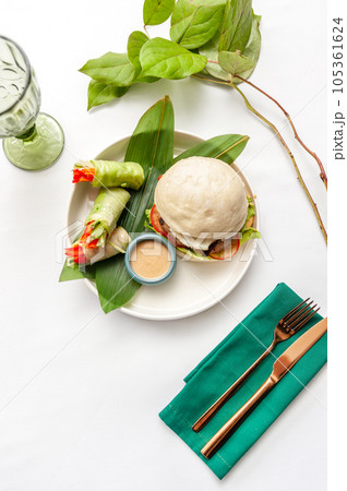 Burger with Bao steamed buns, spring rolls and sesame sauce Burger with Bao steamed buns, spring rolls and sesame sauce 105361624