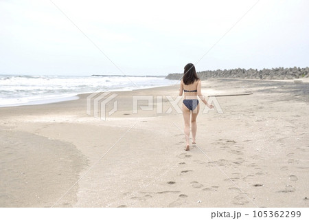 海岸にて水玉のビキニを着た若い女性の後ろ姿 海岸にて水玉のビキニを着た若い女性の後ろ姿 105362299
