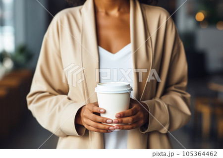 African american woman holding coffee cup close up. Coffee paper cup mock up 105364462