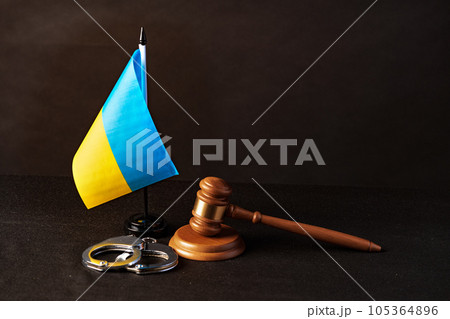 Ukrainian flag and handcuffs on black background, concept of crime and justice in the country 105364896