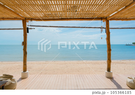 Wooden terrace with roof boho style on the beach in tropical sea 105366185