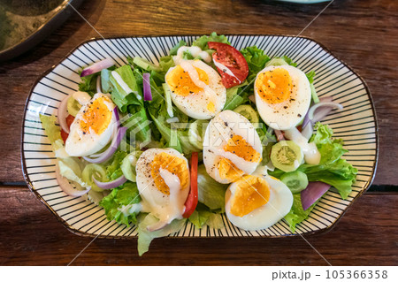 Stir fried mixed salad with boiled egg and sauce, Healthy food in ceramid plate 105366358