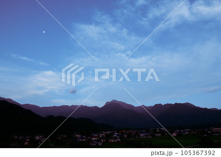 北杜市白州町、南アルプスの峰々に日が射す時、雲上に有明の月 105367392