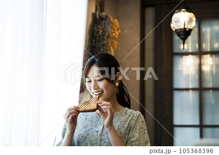 カフェでパンを食べる若い女性 105368396