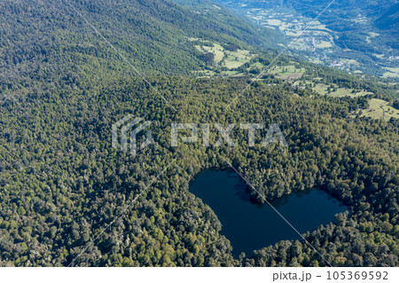 Heart lagoon, Laguna Corazon, Chile. Drone top down view go lagoon with the shape of a heart surrounded by forest, near Liquine, Region Los Lagos Chile Heart lagoon, Laguna Corazon, Chile. Drone top down view go lagoon with the shape of a heart surrounded by forest, near Liquine, Region Los Lagos Chile 105369592