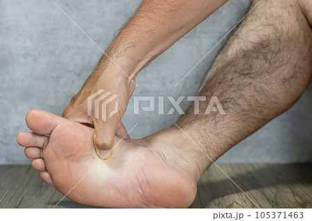 足の裏の胃のツボを押す男性の足の裏 足の裏の胃のツボを押す男性の足の裏 105371463