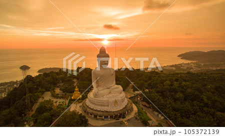 aerial view colorful yellow cloud in golden sky in sunset at Phuket big Buddha. creative travel concept. stunning yellow sky background. Phuket big Buddha is the popular landmark in Phuket. aerial view colorful yellow cloud in golden sky in sunset at Phuket big Buddha. creative travel concept. stunning yellow sky background. Phuket big Buddha is the popular landmark in Phuket. 105372139