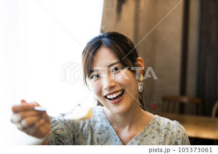 カフェで彼氏にチーズケーキを食べさせる若い女性 105373061