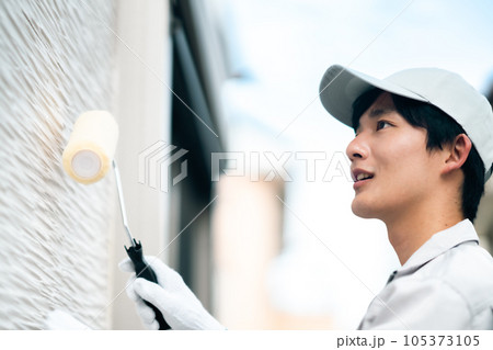 外壁コーティングをする若い男性業者 外壁コーティングをする若い男性業者 105373105