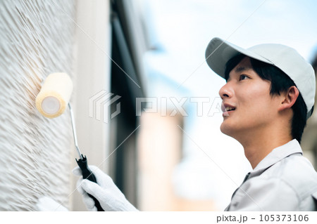 外壁コーティングをする若い男性業者 105373106