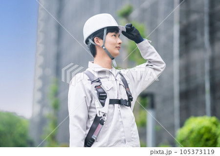 工事現場で働くヘルメット姿の若い男性 105373119
