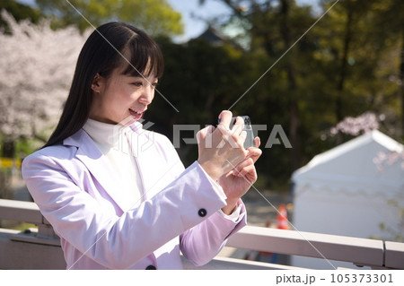 桜の写真をスマホで撮影する若い女性 桜の写真をスマホで撮影する若い女性 105373301