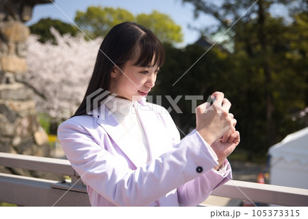 桜の写真をスマホで撮影する若い女性 桜の写真をスマホで撮影する若い女性 105373315