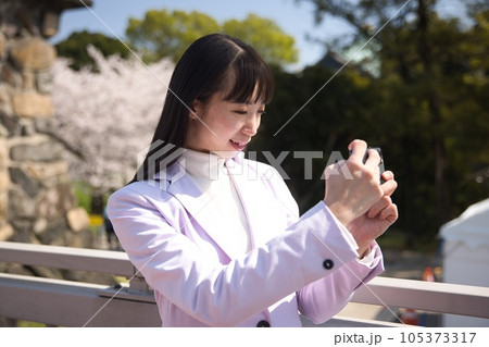 桜の写真をスマホで撮影する若い女性 桜の写真をスマホで撮影する若い女性 105373317