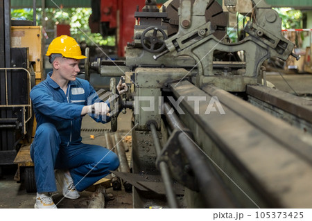 Caucasian man engineering workers wear yellow hard hat working machine lathe metal. 105373425