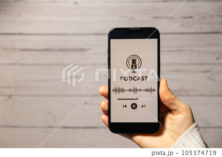 Unrecognizable woman holding mobile phone Podcast listening website page app application with wireless headphones. Audio healing, sound therapy wellness rituals, positive mental health habits 105374719