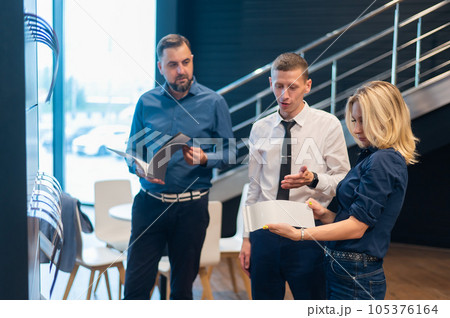 Caucasian couple chooses the color of a new car in a car dealership. Caucasian couple chooses the color of a new car in a car dealership. 105376164