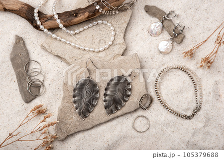 Beautiful Silver and Pearl Jewelry on white stones and sand. Various jewelry - bracelets, necklaces and rings. Beautiful Silver and Pearl Jewelry on white stones and sand. Various jewelry - bracelets, necklaces and rings. 105379688