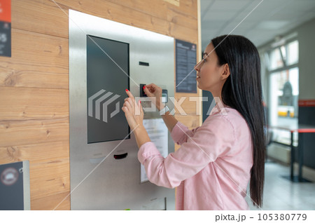 Woman buying coffee from automatic vending machine. Woman buying coffee from automatic vending machine. 105380779