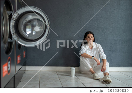 Woman waiting in public laundry room. Woman waiting in public laundry room. 105380839