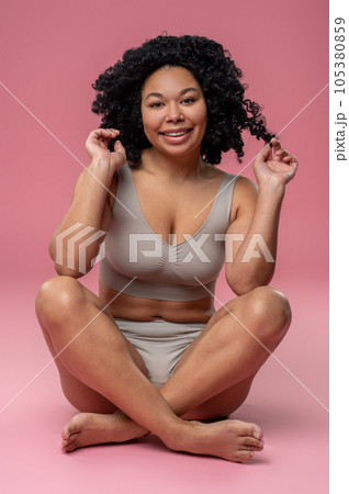 Smiling contented woman on a pink background Smiling contented woman on a pink background 105380859