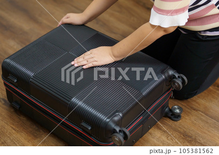 Woman preparing luggage  packing in suitcase  trolley luggage traveling alone solo girl. 105381562