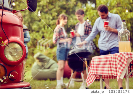 Blurred image of people, friends meeting together, making barbecue party, drinking cocktails and enjoying warm day 105383178