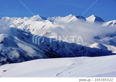 Mountain with snow. Alps. Switzerland. Panoramic view of the Snowy Alps and blue sky around the Titlis mountain. French Alps. Alpine mountains. Descent peaks on the Austrian snow slopes. ski slopes. Mountain with snow. Alps. Switzerland. Panoramic view of the Snowy Alps and blue sky around the Titlis mountain. French Alps. Alpine mountains. Descent peaks on the Austrian snow slopes. ski slopes. 105385522
