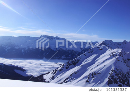 Mountain with snow. Alps. Switzerland. Panoramic view of the Snowy Alps and blue sky around the Titlis mountain. French Alps. Alpine mountains. Descent peaks on the Austrian snow slopes. ski slopes. 105385527