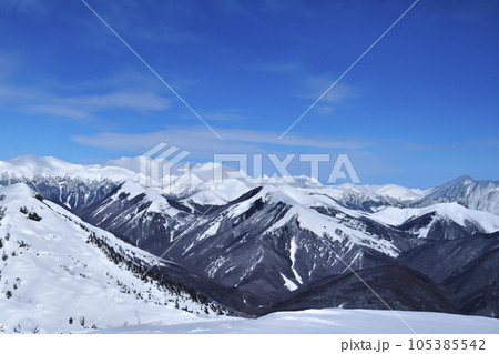 Mountain with snow. Alps. Switzerland. Panoramic view of the Snowy Alps and blue sky around the Titlis mountain. French Alps. Alpine mountains. Descent peaks on the Austrian snow slopes. ski slopes. 105385542