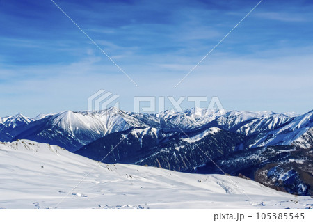 Mountain with snow. Alps. Switzerland. Panoramic view of the Snowy Alps and blue sky around the Titlis mountain. French Alps. Alpine mountains. Descent peaks on the Austrian snow slopes. ski slopes. Mountain with snow. Alps. Switzerland. Panoramic view of the Snowy Alps and blue sky around the Titlis mountain. French Alps. Alpine mountains. Descent peaks on the Austrian snow slopes. ski slopes. 105385545