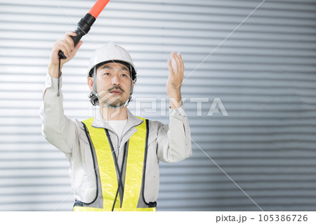 倉庫の中でオーライ～と誘導する警備員や作業員など　安全ベスト付き 105386726