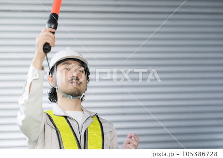 倉庫の中で誘導する警備員や作業員など　安全ベスト付き 105386728